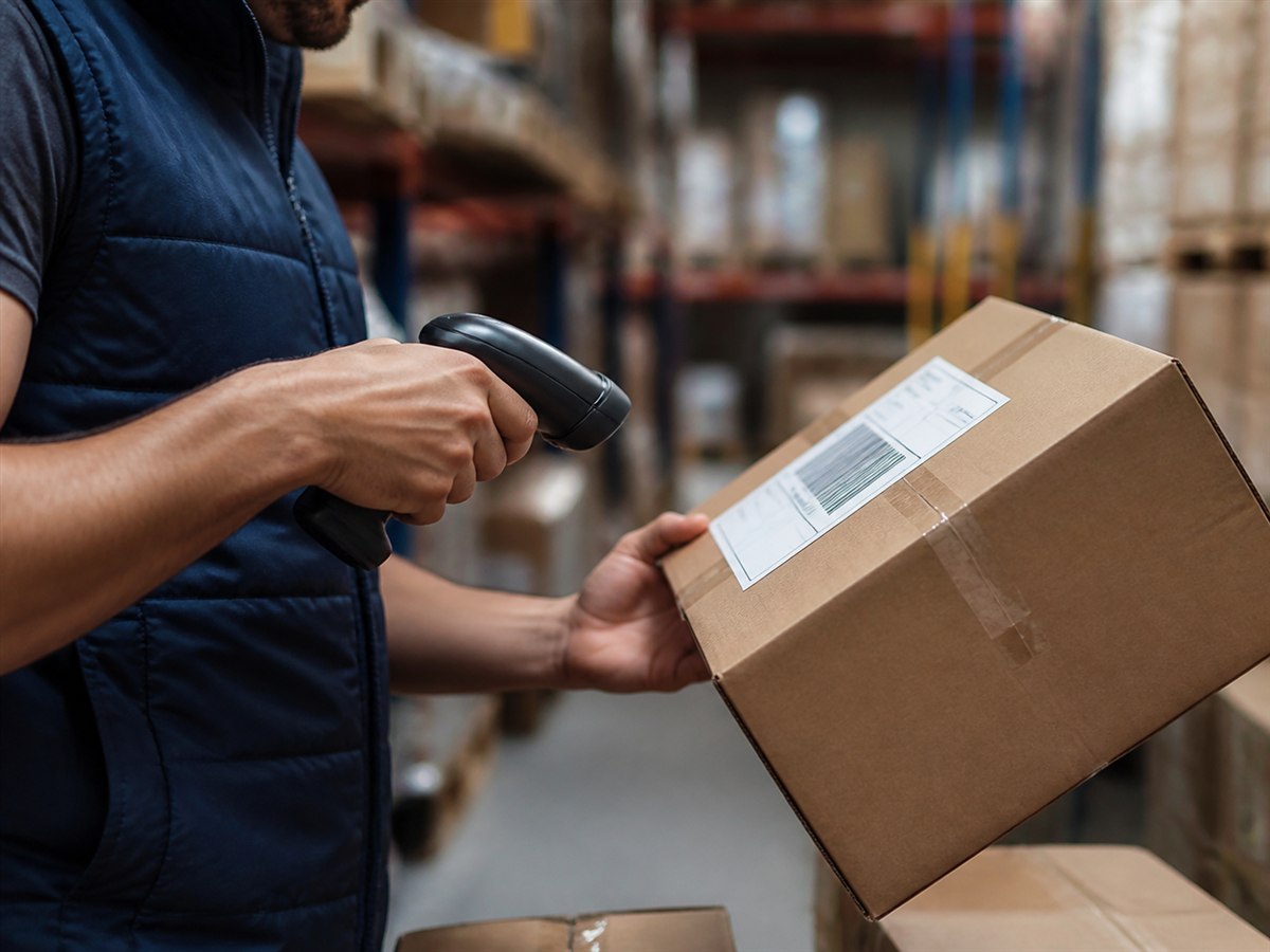 Depoda paketin barkodunu el terminaliyle okutan çalışan